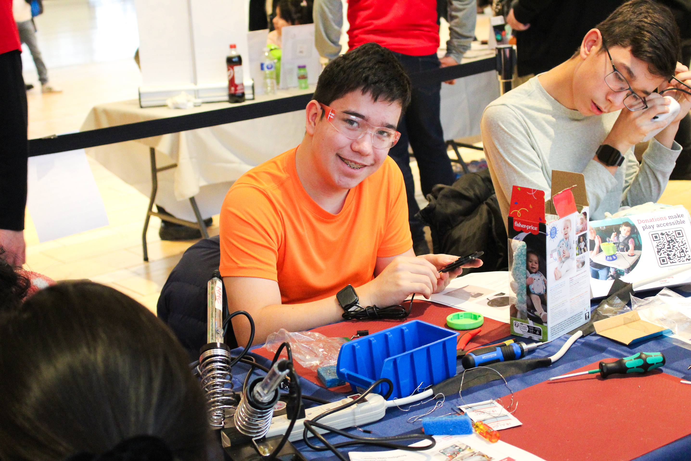 A boy smiles as he works on a toy.