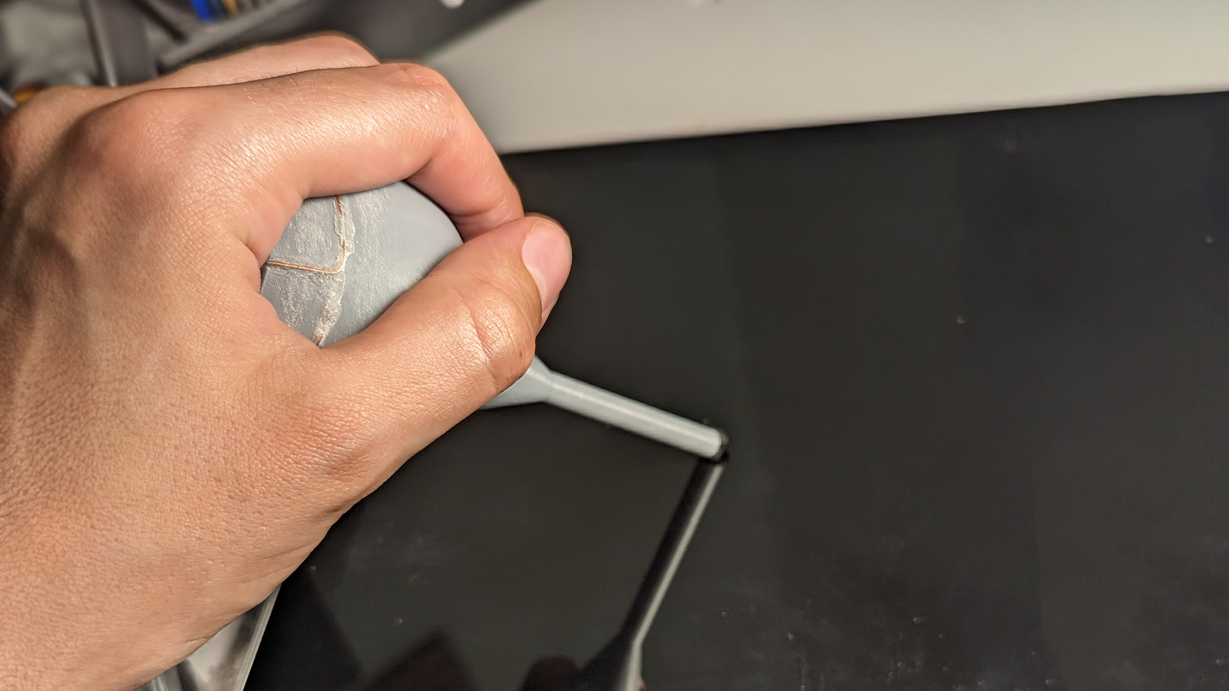 Person holding Palm Ball Stylus and pressing the tip against a touch screen