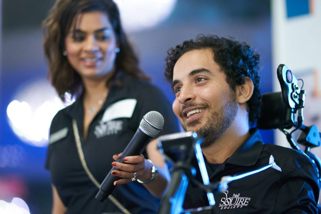 Omar, an MMC volunteer, speaks into a mic while an MMC staff holds it.