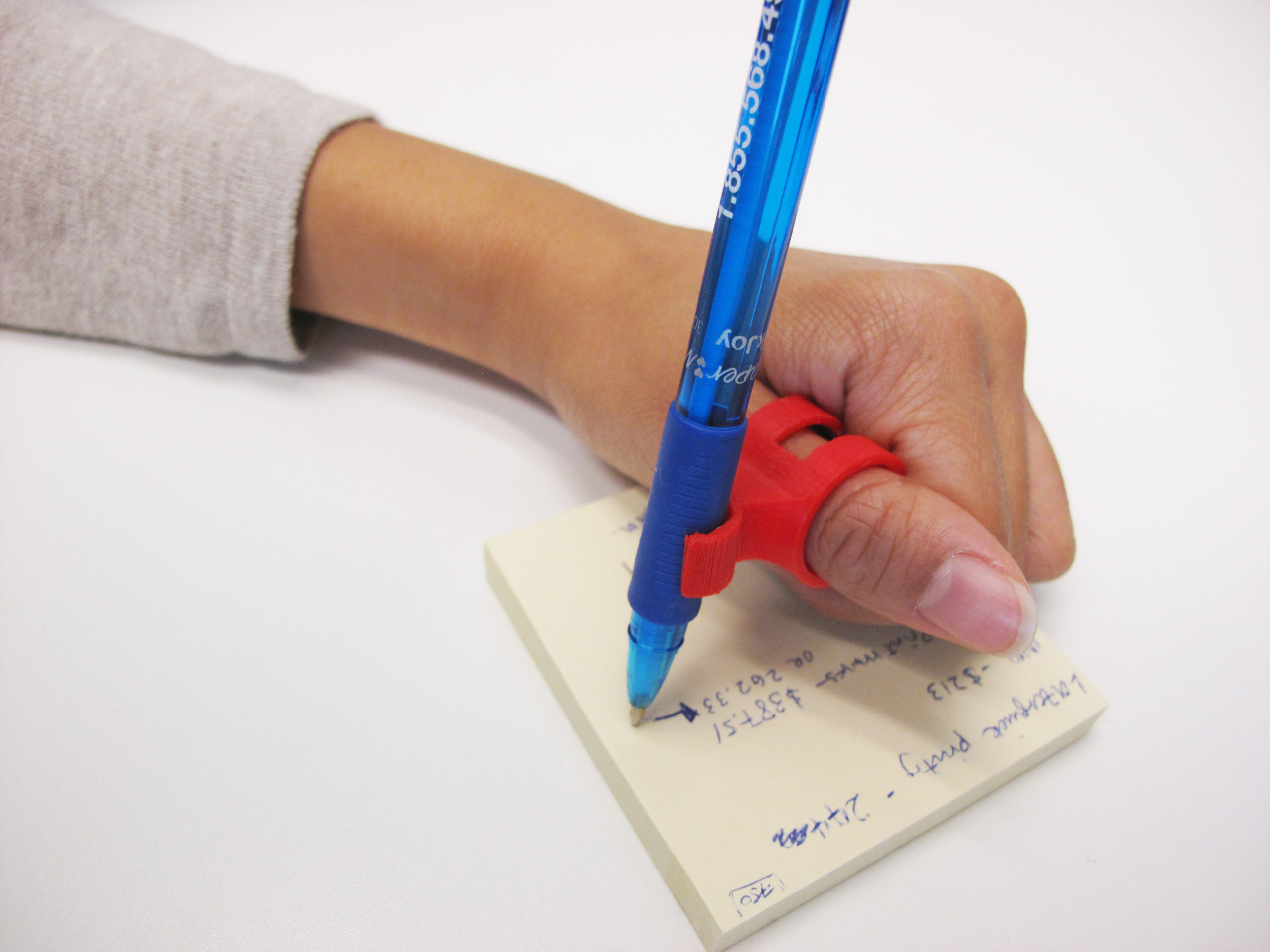 A user using the 3D Printed finger pen holder to write with ease