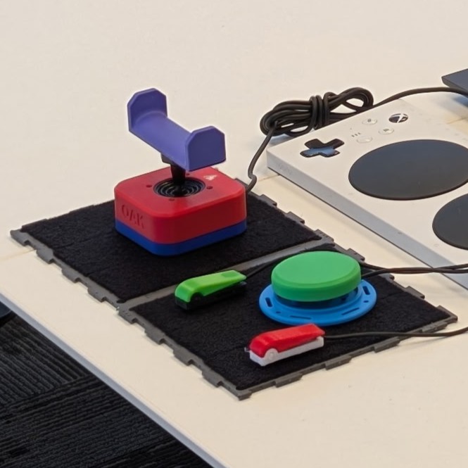 A Connect Board AT mounting surface as part of an adaptive gaming setup with joysticks and switches.