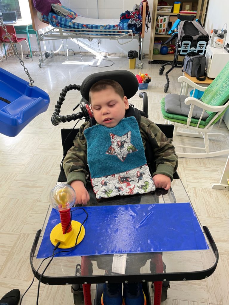 A child with a disability resting their eyes in a classroom.