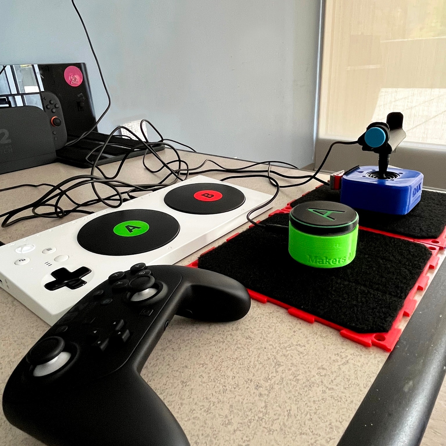An Xbox Adaptive Controller with a controller, switch, and joystick.