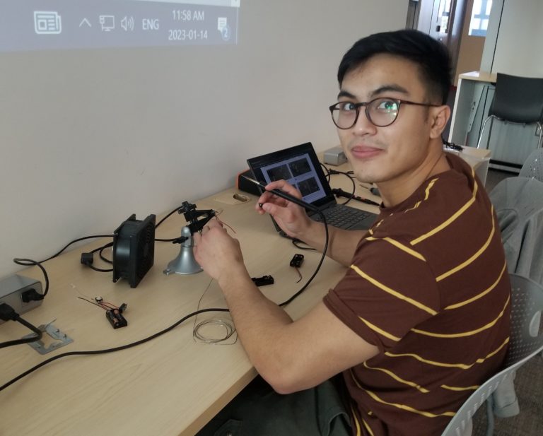 A UVIC student soldering.