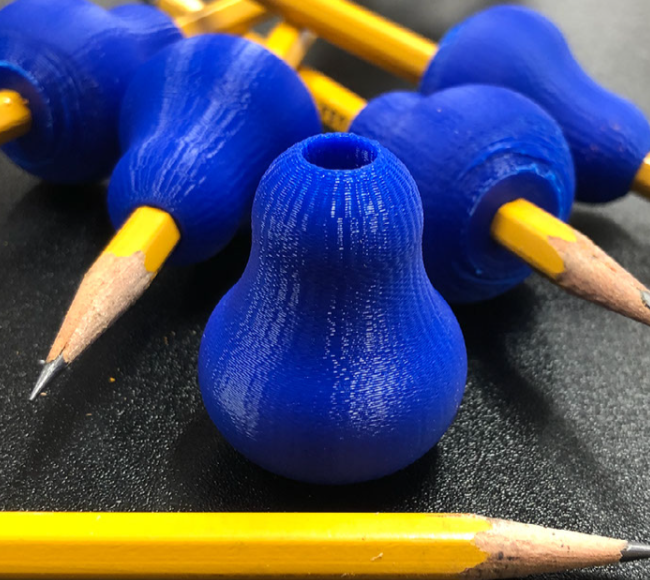 Blue pencil grip devices being used with pencils.