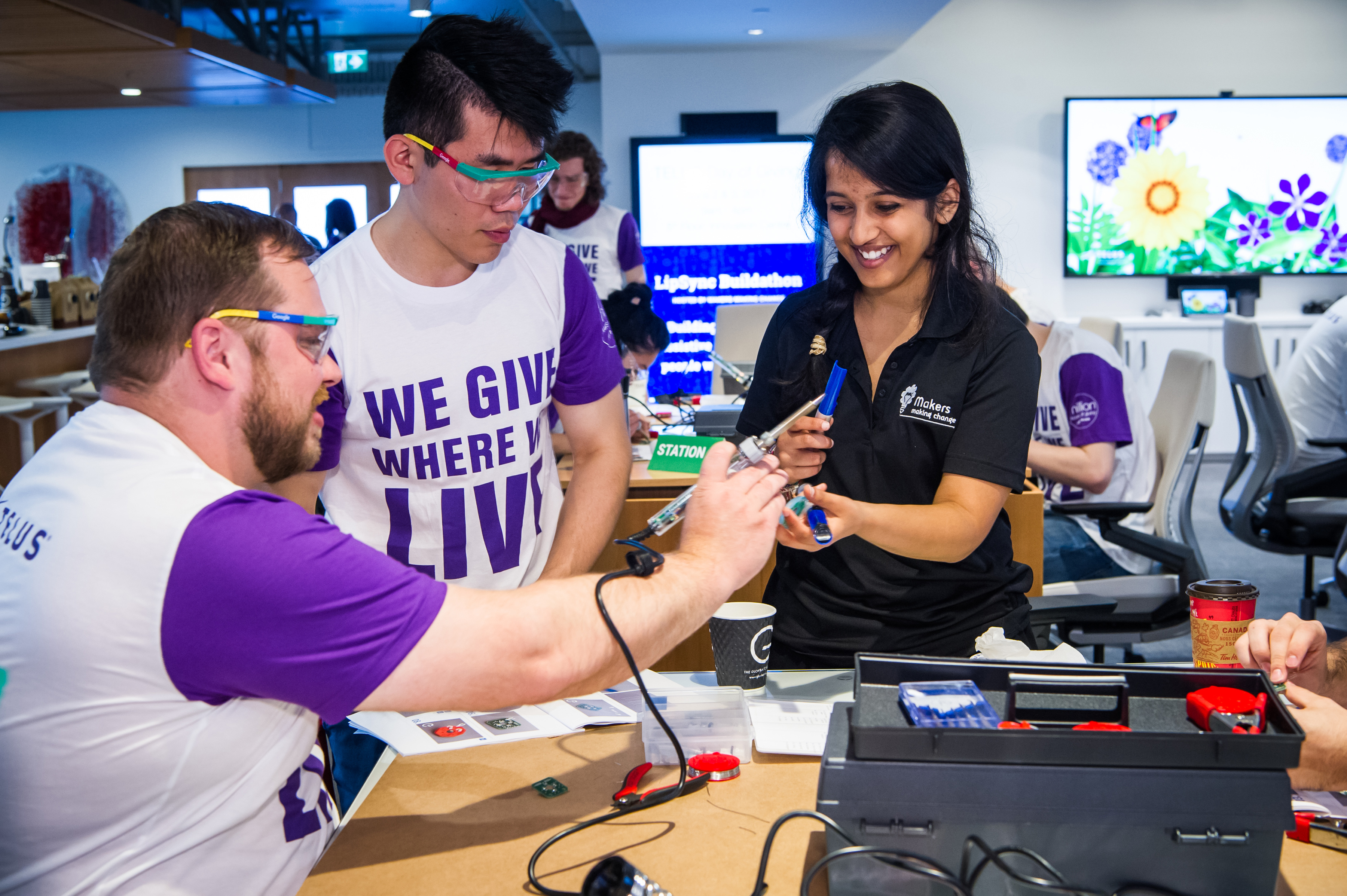 Rashmi helping two Telus employees at an early Makers Making Change build event.