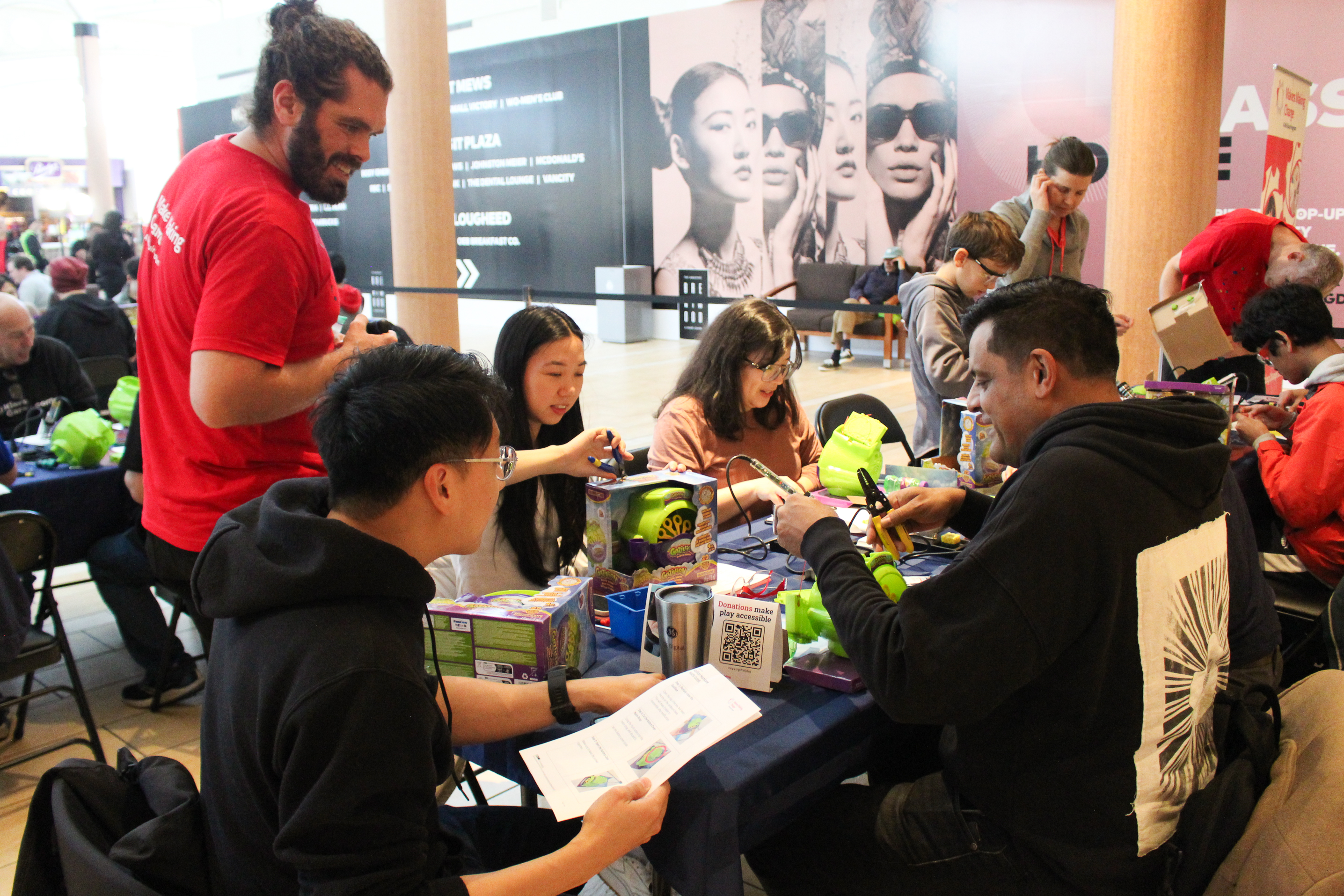 Reed helping volunteers build devices.