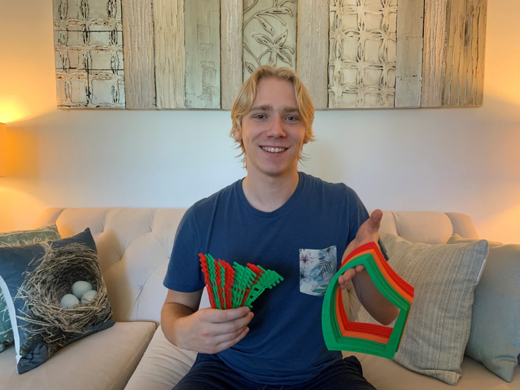 Birk from MMC holding 3D printed parts and smiling.