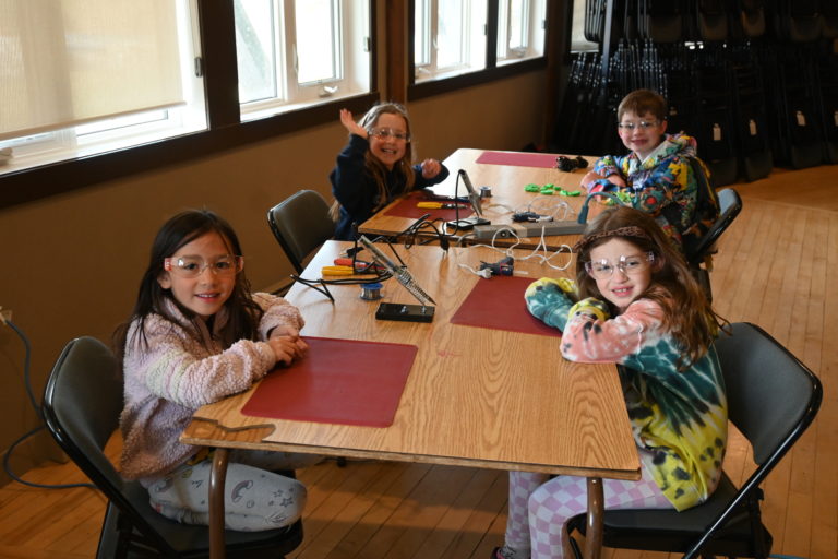 Four children smiling at a build event.