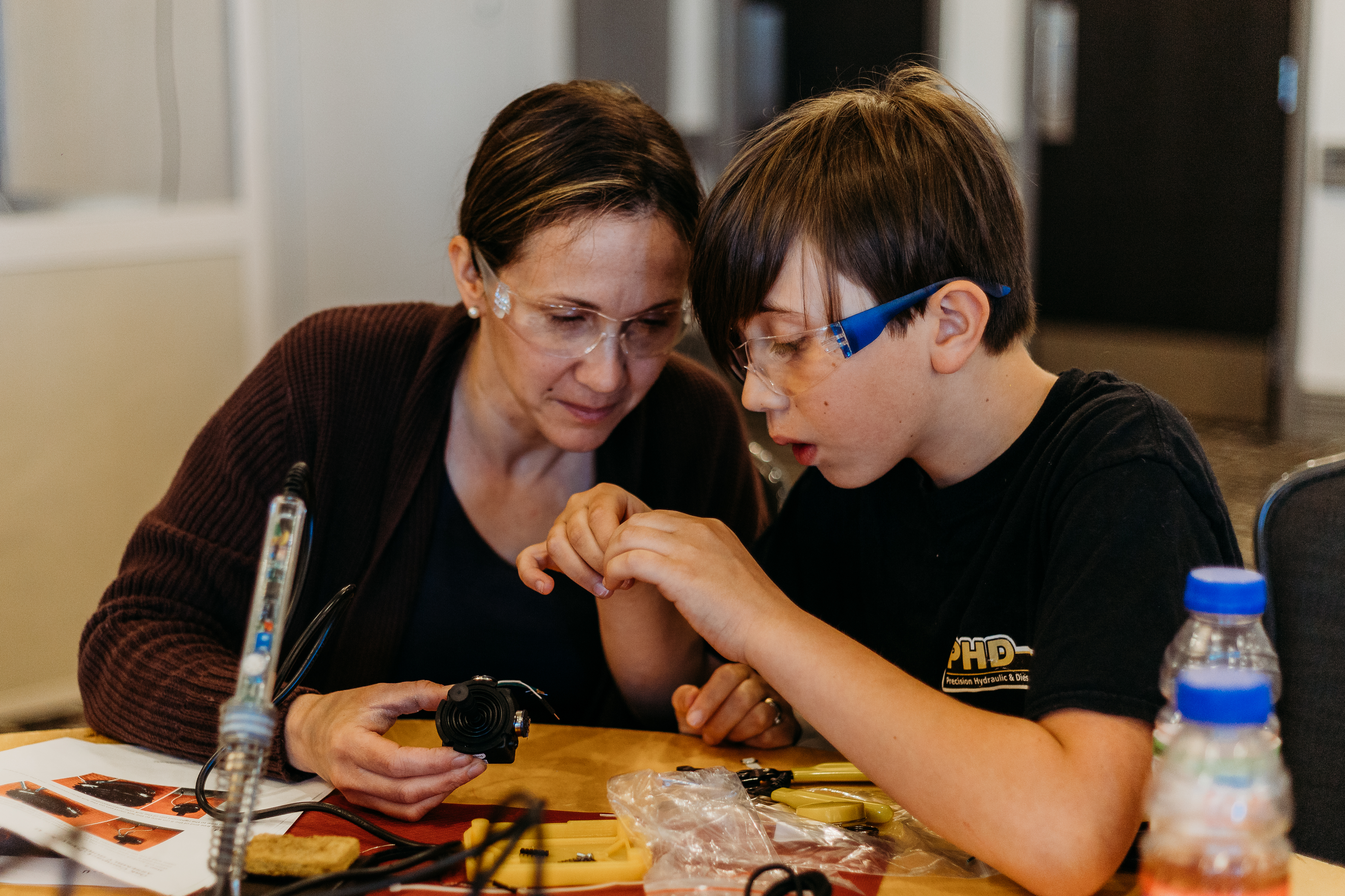 Two volunteers examining components at a build event.