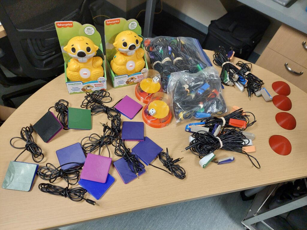 Assistive devices and switch-adapted toys on a table.