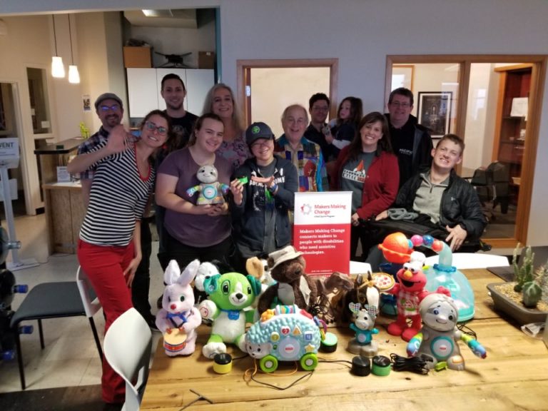 A group of volunteers surrounding a table filled with toys.