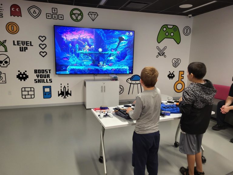 Two boys using assistive switches to game.