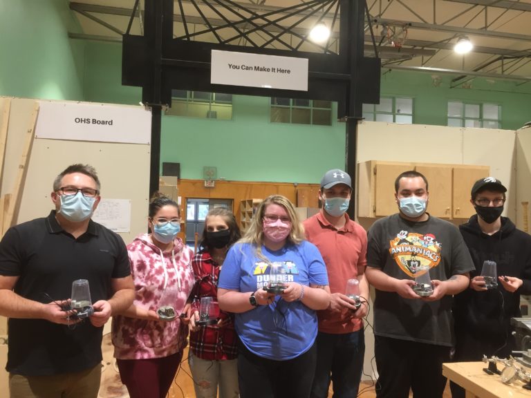 Volunteers holding assistive devices.