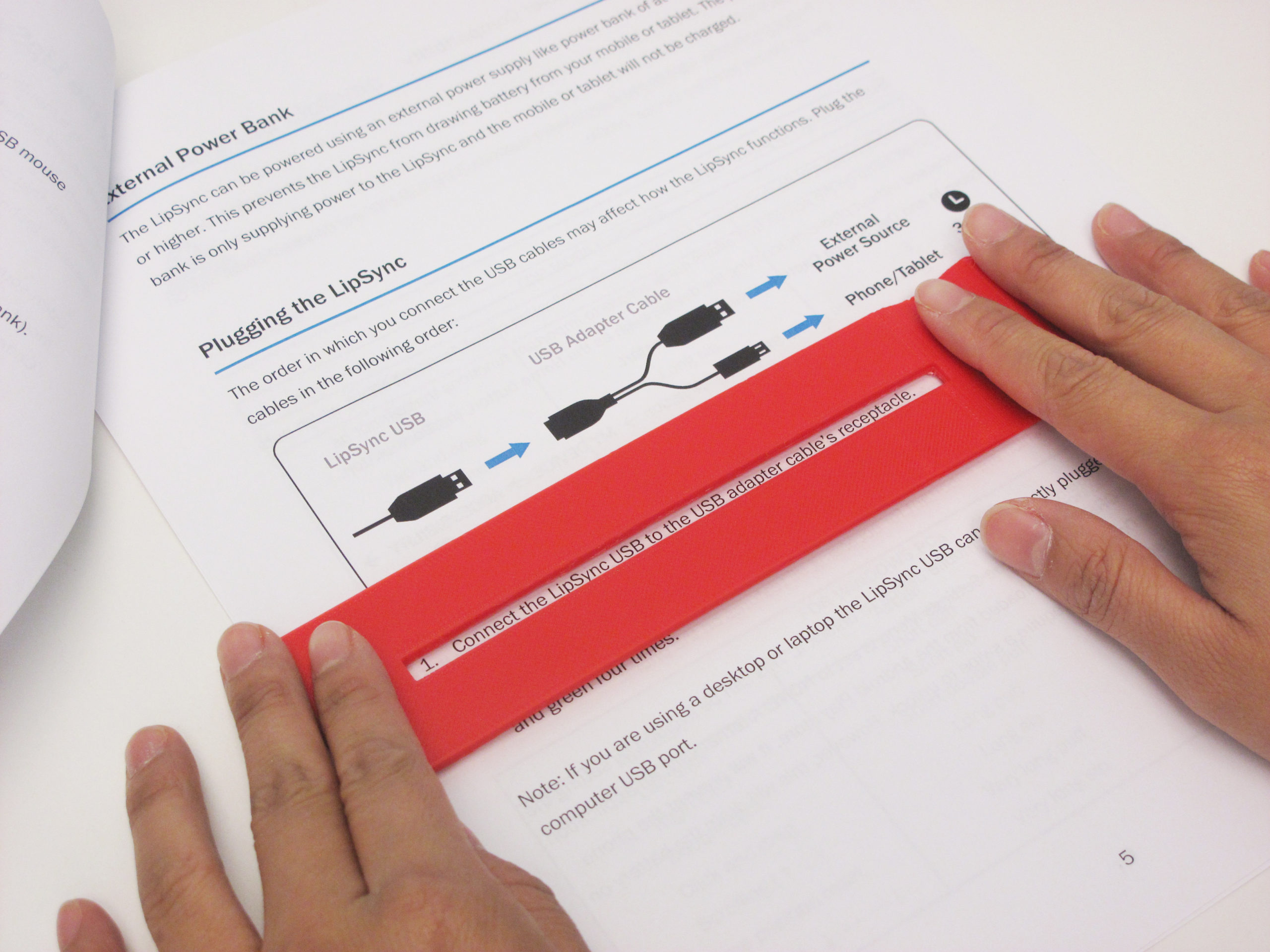 A user with dyslexia using the Flat Reading Bar to read the instruction manual with ease